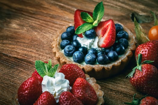 Sweet desserts with strawberry and blueberry on wooden table