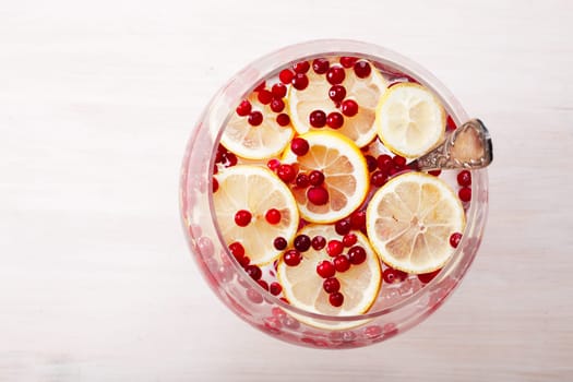 Cranberry lemon detox water in a glass jar. Healthy water with infused cranberry, cowberry and lemon
