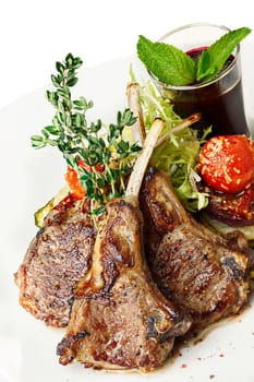 Fried lamb rack with vegetable garnish. Lamb chop dinner.
