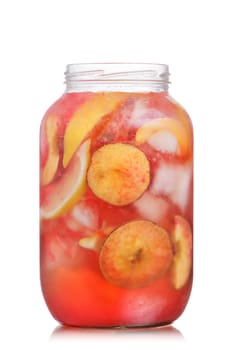 Jar of carbonated peach lemonade garnished with peach wheel and lemon slice. Glass jar full of cold peach spritzer with peach and lemon slices.