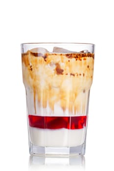 Layered iced milkshake with strawberry syrup, condensed milk and chocolate. Delicious milk cocktail in highball glass