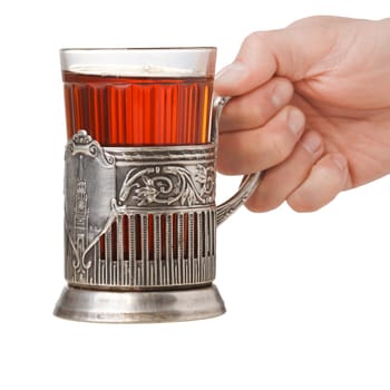Hand holding a soviet faceted glass of tea in vintage glass-holder (podstakannik)