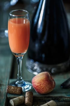 Famous Italian Bellini alcoholic cocktail made from pink peach puree with prosecco. Official IBA cocktail. Natural lighting, rustic styled, very narrow depth of field, selective focus