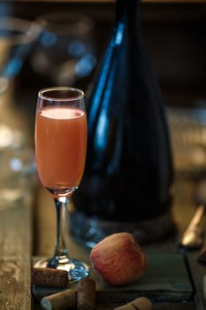 Famous Italian Bellini alcoholic cocktail made from pink peach puree with prosecco. Official IBA cocktail. Natural lighting, rustic styled, very narrow depth of field, selective focus