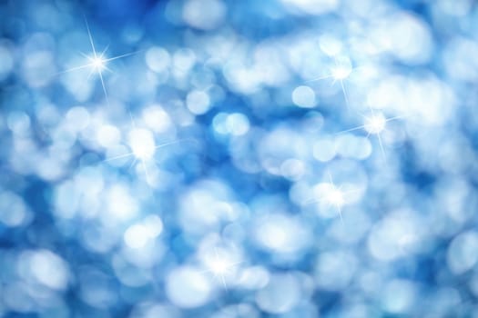 Out of focus lights creating a blue bokeh background with bright highlights,ideal for Christmas