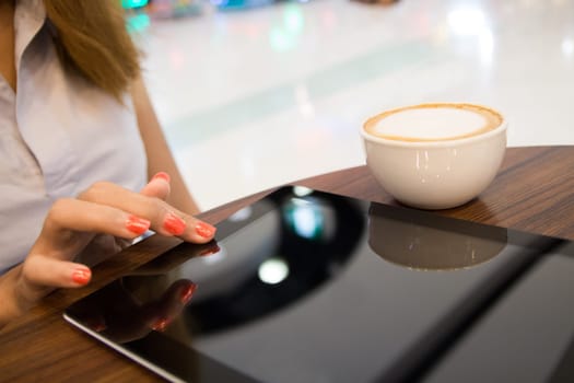 close up women using tablet shopping online in coffee shop