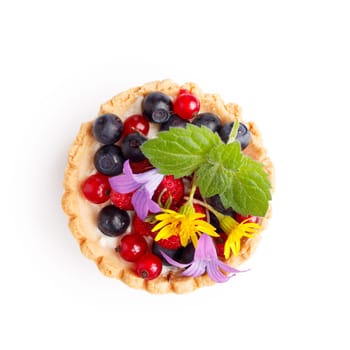 Dessert with wild berries decorated with mint leaves and wildflowers. Sweet tart with wild strawberry, blueberry and red currant. Large DOF
