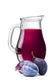 Fresh plum juice in a pitcher. Full jug of plum drink with plums on foreground