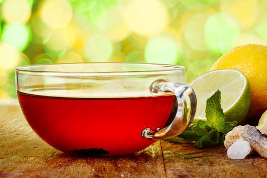 A cup of hot tea on wooden table against spring blurred background. Tea time concept