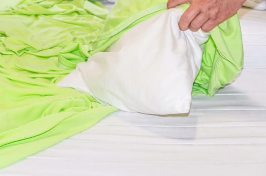 Close up on green bedding. Bed linen and pillows,are re-covered. Bed concept