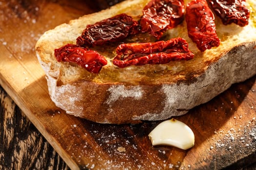 Bruschetta with dried tomatoes, garlic and olive oil. Traditional Italian cuisine sandwich made of grilled ciabatta. Antipasti
