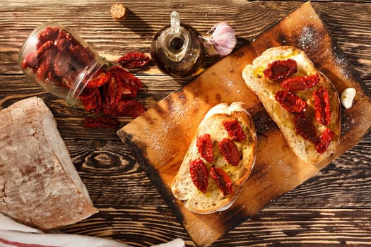 Bruschetta with dried tomatoes, garlic and olive oil. Traditional Italian cuisine sandwich made of grilled ciabatta. Antipasti