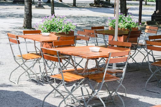 Table and chairs in the outdoor area of a restaurant. Beer garden awaits its guests.