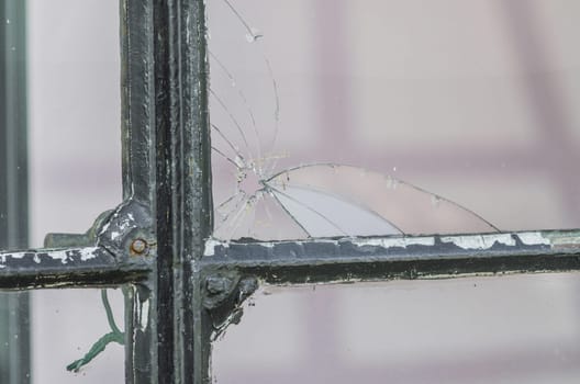 A hole in the window pane. A broken glass pane - pierced by ball.