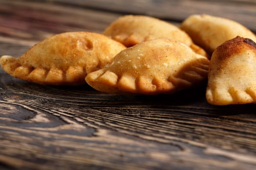 Fried colombian empanadas on wooden table. Savory stuffed patties also known as pastel,pate or pirozhki