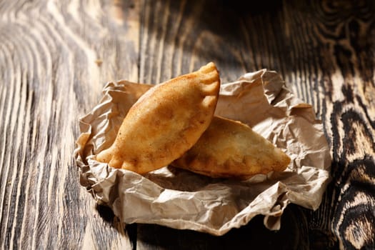 Fried colombian empanadas on wooden table. Savory stuffed patties also known as pastel,pate or pirozhki