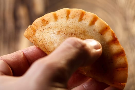 Male hand holding fried colombian empanada. Savory stuffed patties also known as pastel,pate or pirozhki