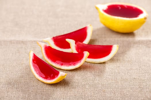 Lemon tequila strawberry jelly (jello) shots on a linen clothed table. Unusual adult party drinks