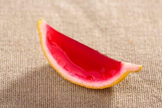 Lemon tequila strawberry jelly (jello) shot on a linen clothed table. Unusual adult party drink