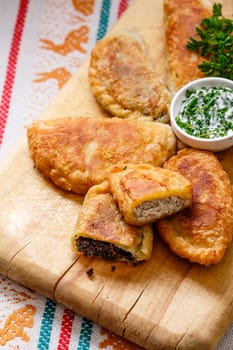 Colombian empanadas (snack sized savory patties) on wooden board. Latin cuisine