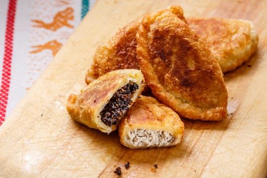 Colombian empanadas (snack sized savory patties) on wooden board. Latin cuisine