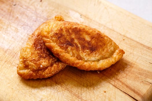 Colombian empanadas (snack sized savory patties) on wooden board. Latin cuisine