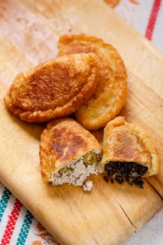 Colombian empanadas (snack sized savory patties) on wooden board. Latin cuisine