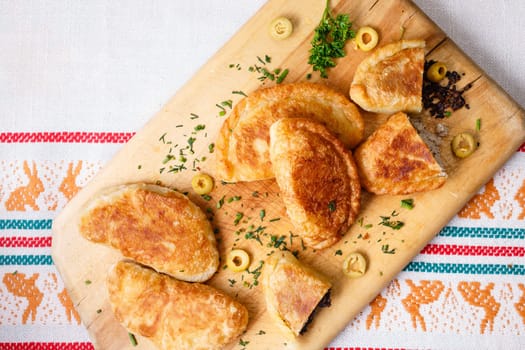 Colombian empanadas (snack sized savory patties) on wooden board. Latin cuisine