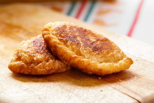 Colombian empanadas (snack sized savory patties) on wooden board. Latin cuisine
