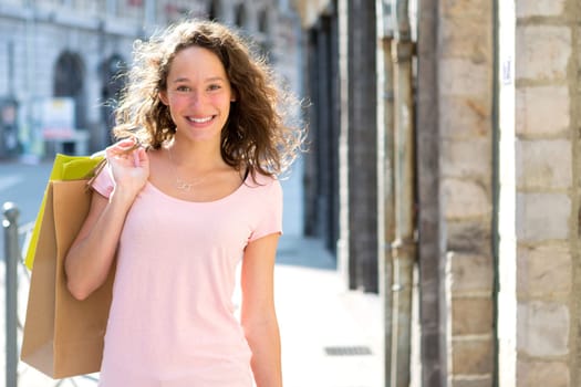 View of a Young attractive happy woman shopping in the city