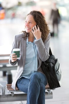 View of a Young attractive business woman using smartphone drinking coffee