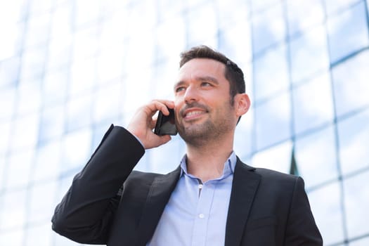 View of a Young attractive business man using smartphone