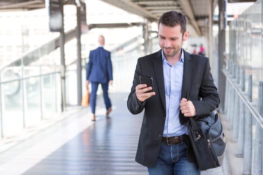 View of a Young attractive business man using smartphone