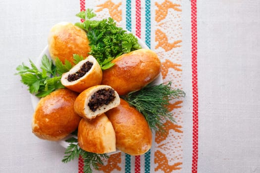 Russian pirozhki (baked patties) on wooden cutboard