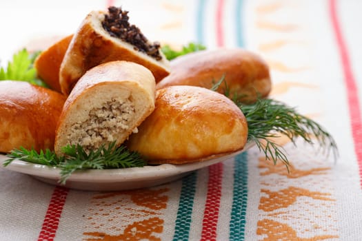 Russian pirozhki (baked patties) on wooden cutboard