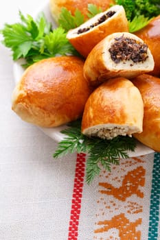 Russian pirozhki (baked patties) on wooden cutboard