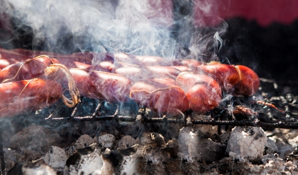 Close up view of many chorizos on a barbecue