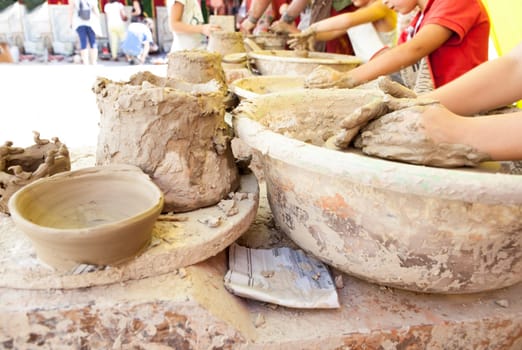 Children learning to work with potter's wheel