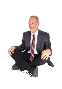 A happy smiling middle age businessman in a suit, sitting on the floor.isolated for white background..