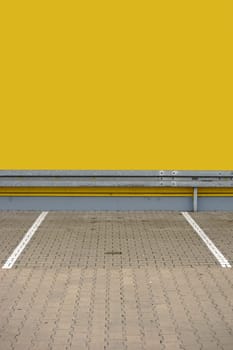 A single parking lot with markings and a guardrail at the end.