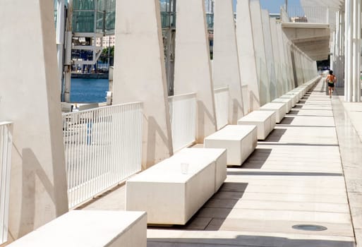 Sweaty  sportsman running under Malaga main boardwalk a sunny day with blue sky
