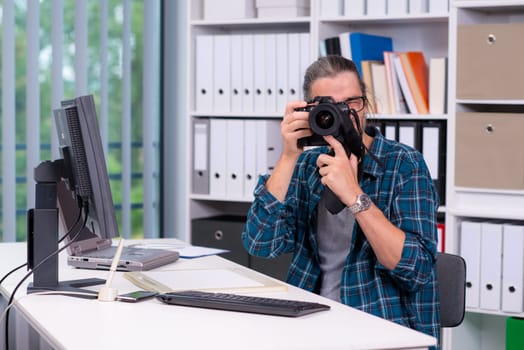 creative man with camera is working in his office