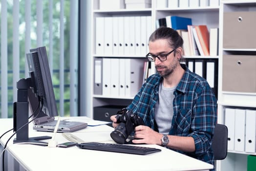 creative man with camera is working in his office
