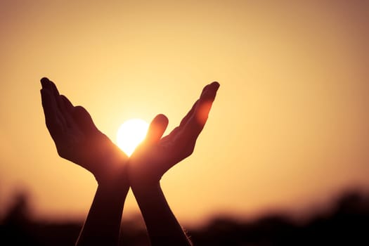 silhouette of female hands during sunset