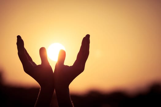 silhouette of female hands during sunset