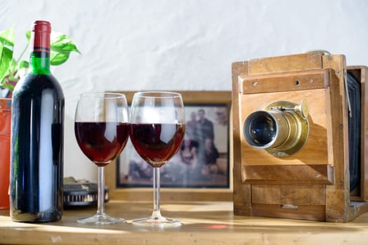glasses  and bottle of wine with an old camera