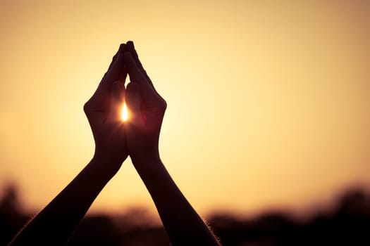 silhouette of female hands during sunset