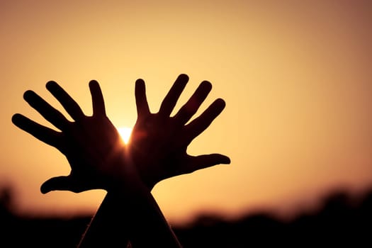 silhouette of female hands during sunset