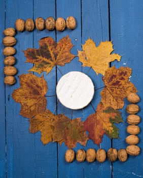 French cheese with nuts on a wooden table painted blue
