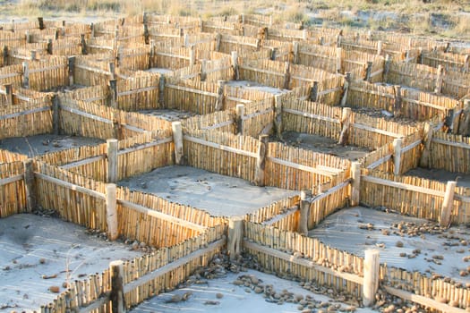Barrier for sand. Useful against shoreline erosion